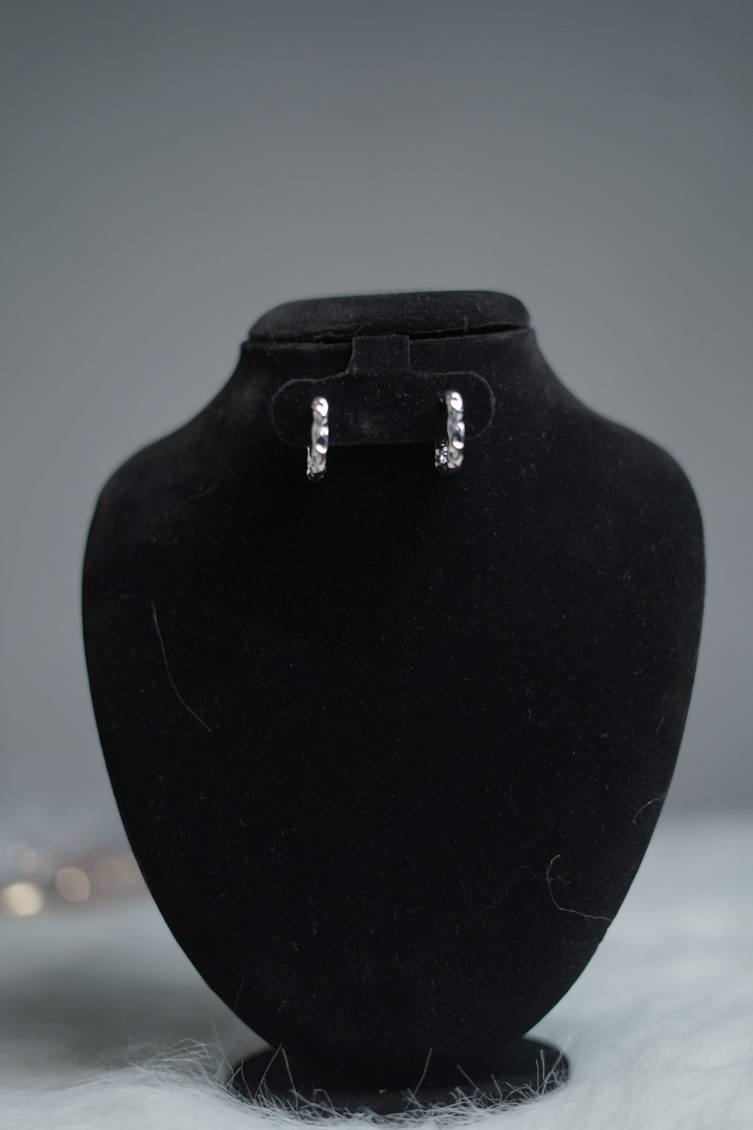 Molten Wave Square Hoops displayed on a jewelry stand with polished antique silver finish and square shape.