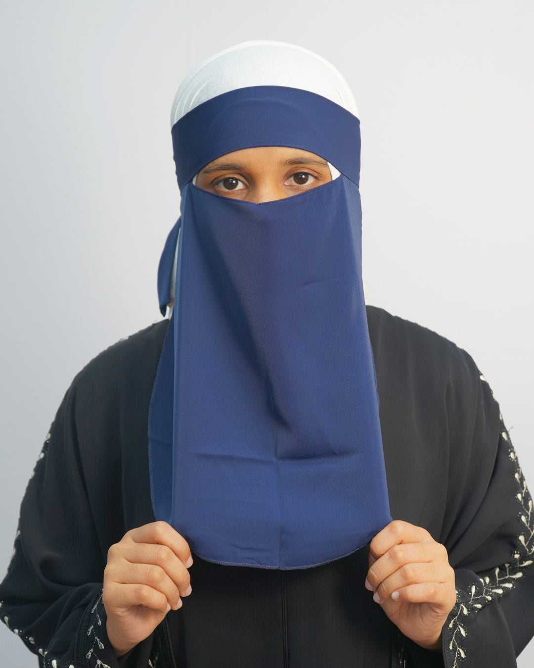 Woman wearing a one-layer navy blue niqab with tie-back design.