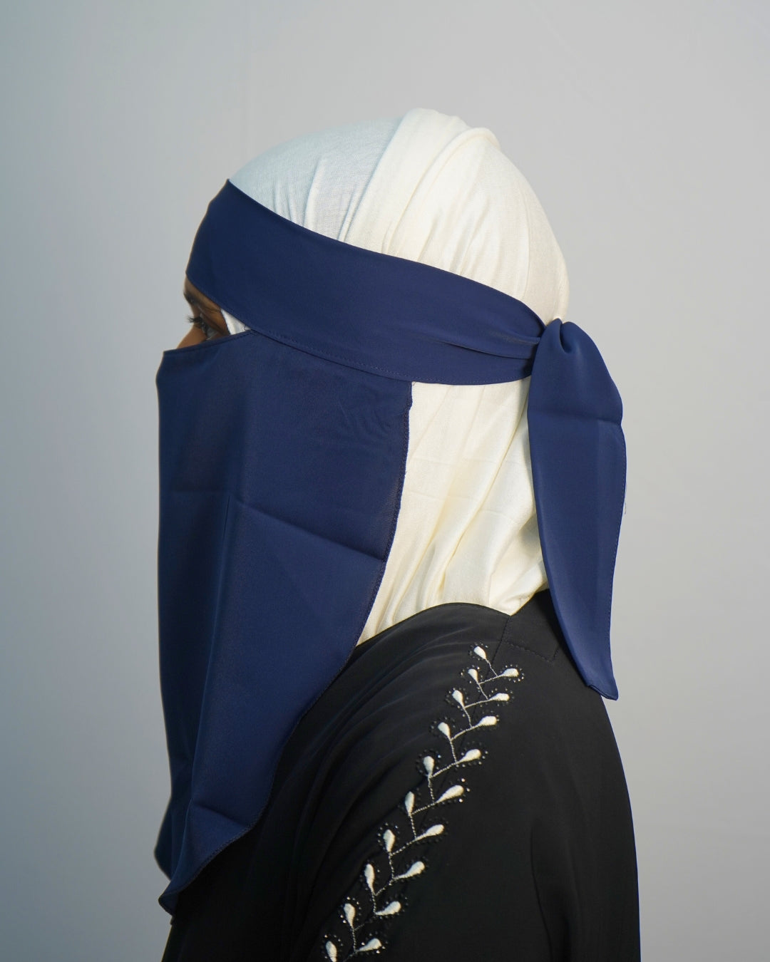 Side view of navy blue crepe chiffon niqab with adjustable straps.