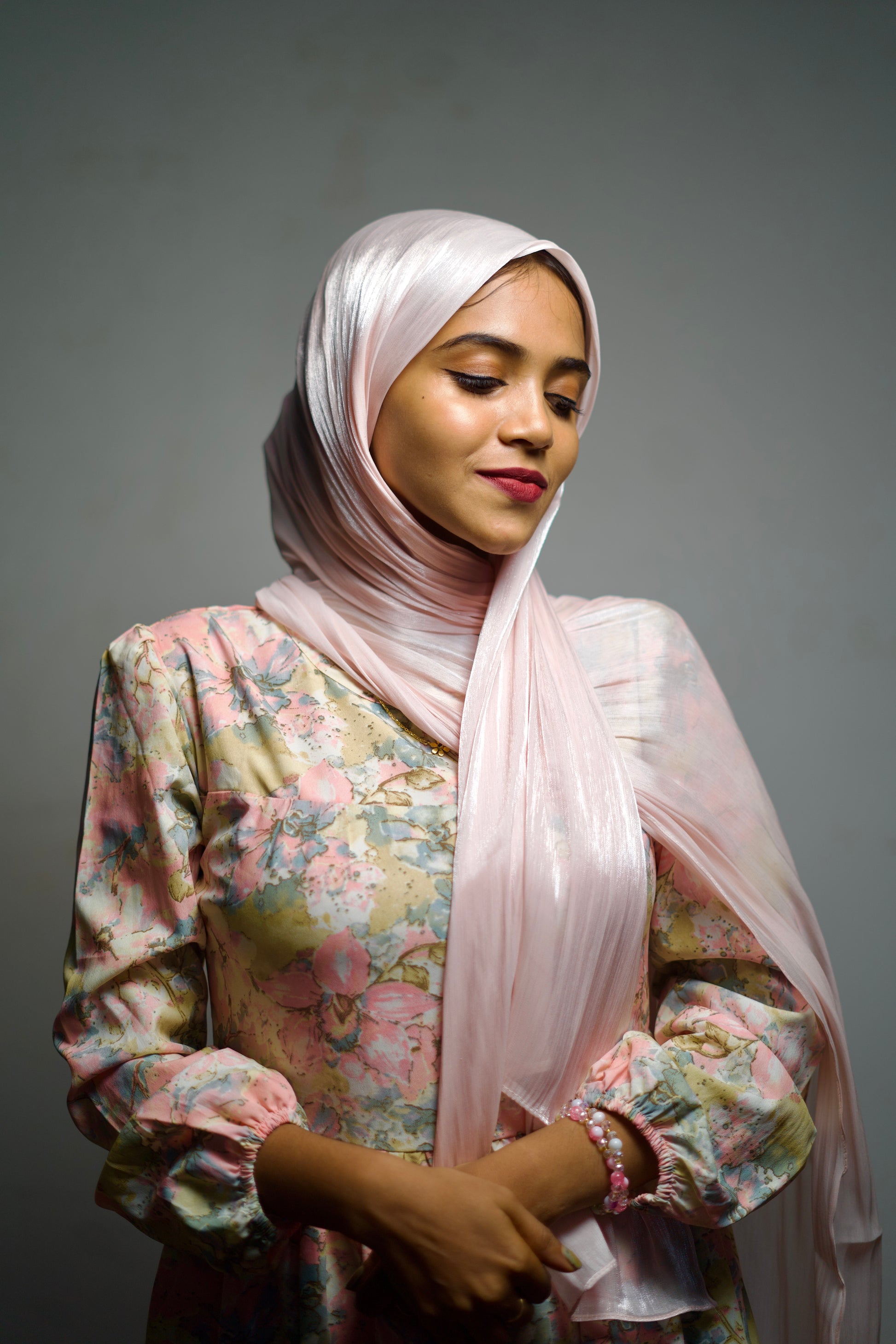 Soft pastel shimmer hijab draped gently around the face with a clean edge.