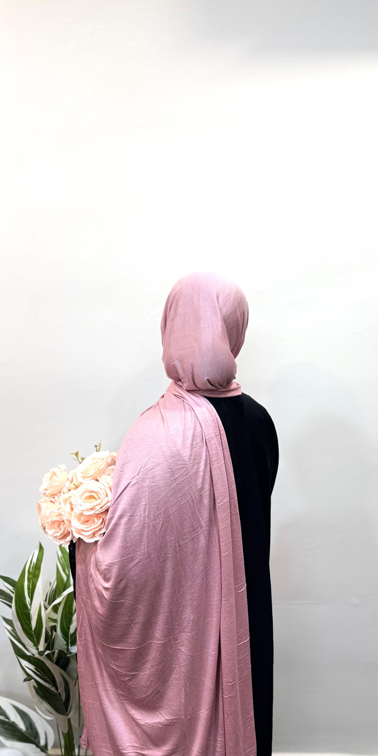 Relaxed pink jersey hijab flowing gently over the shoulders.