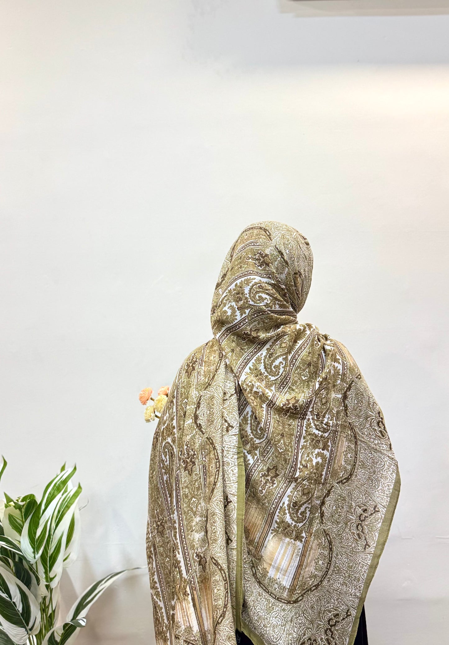 Light pistachio green pashmina hijab with subtle paisley patterns.