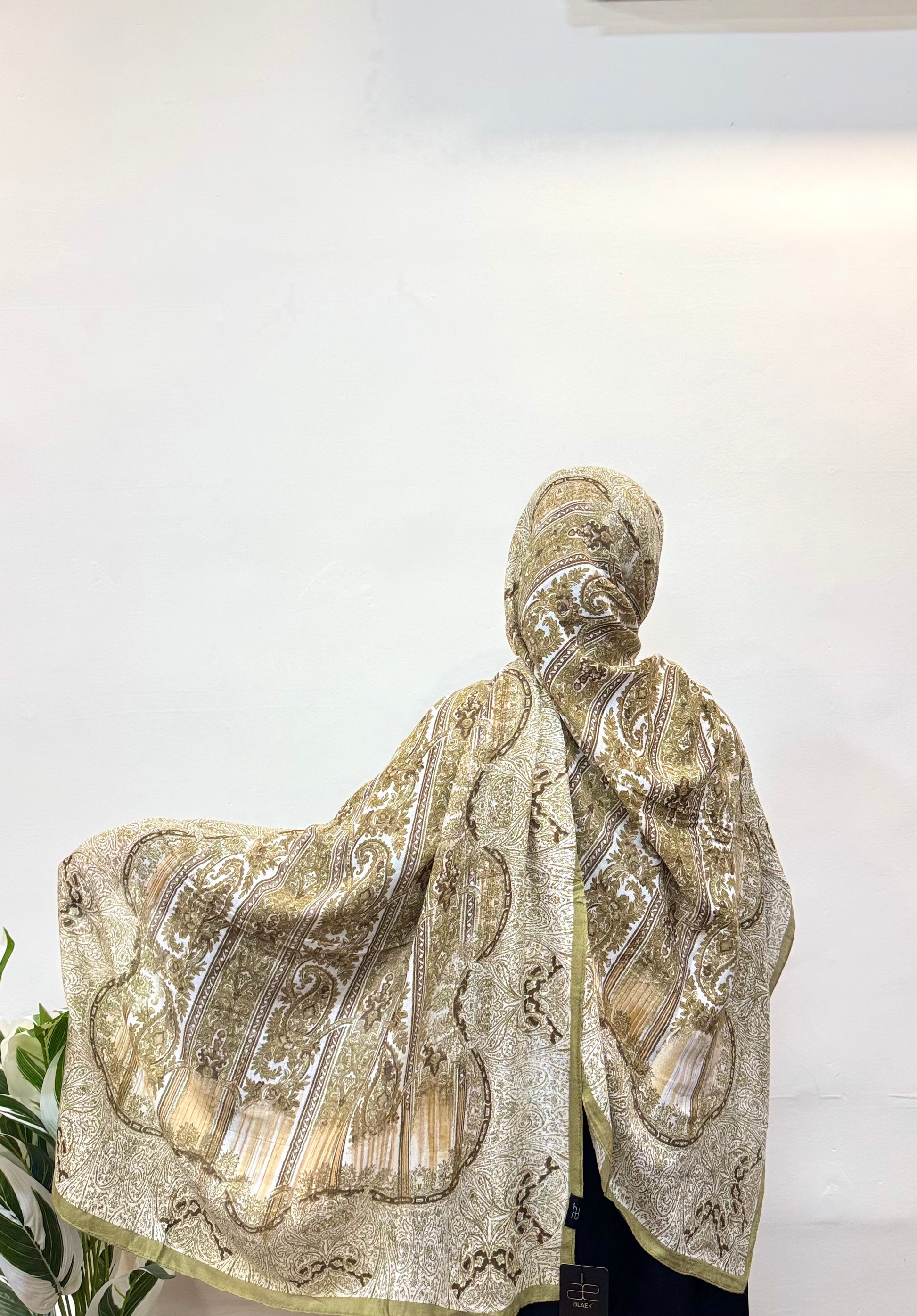 Light pistachio green pashmina hijab with subtle paisley patterns.