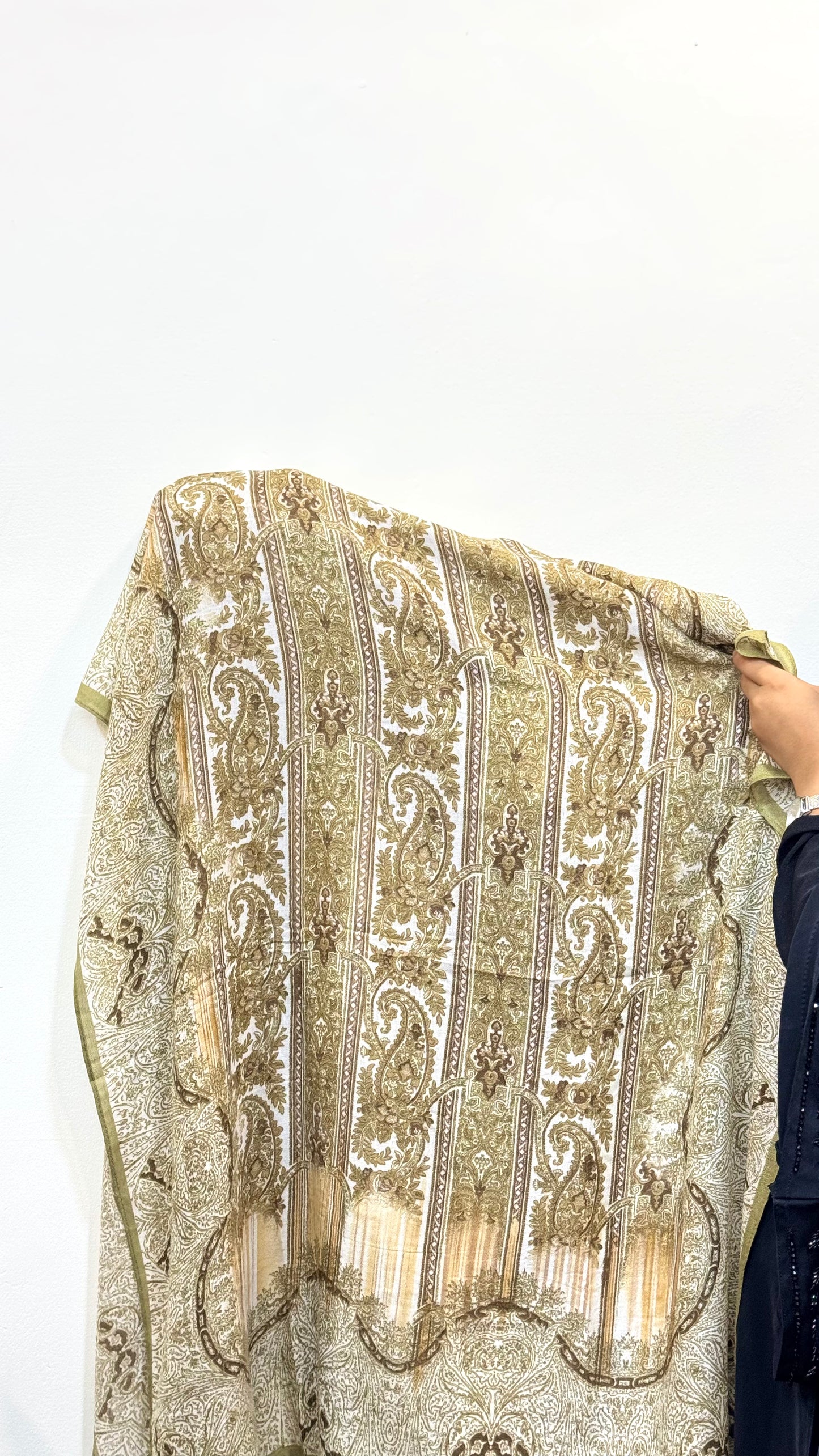 Light pistachio green pashmina hijab with subtle paisley patterns.