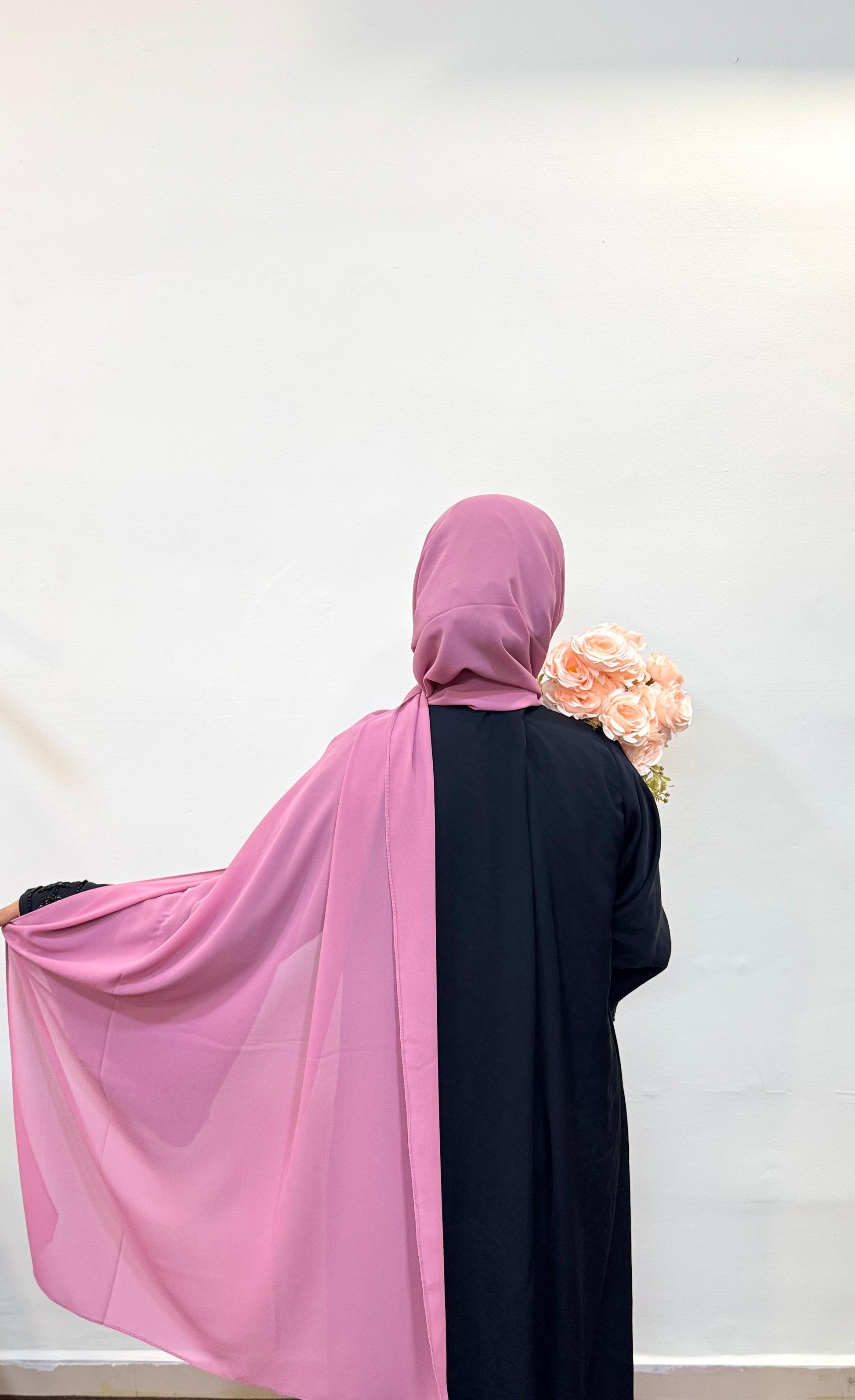 Back view of a woman in pardha wearing a puce chiffon scarf.