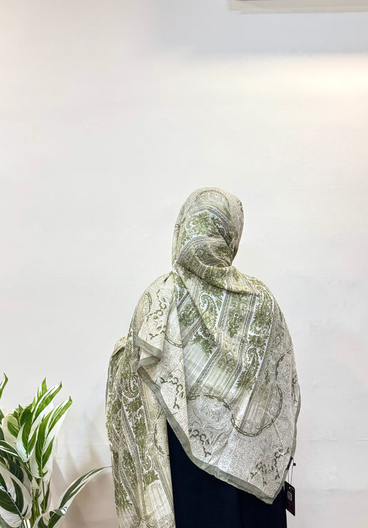 Worn sage green pashmina hijab with neat drape.
