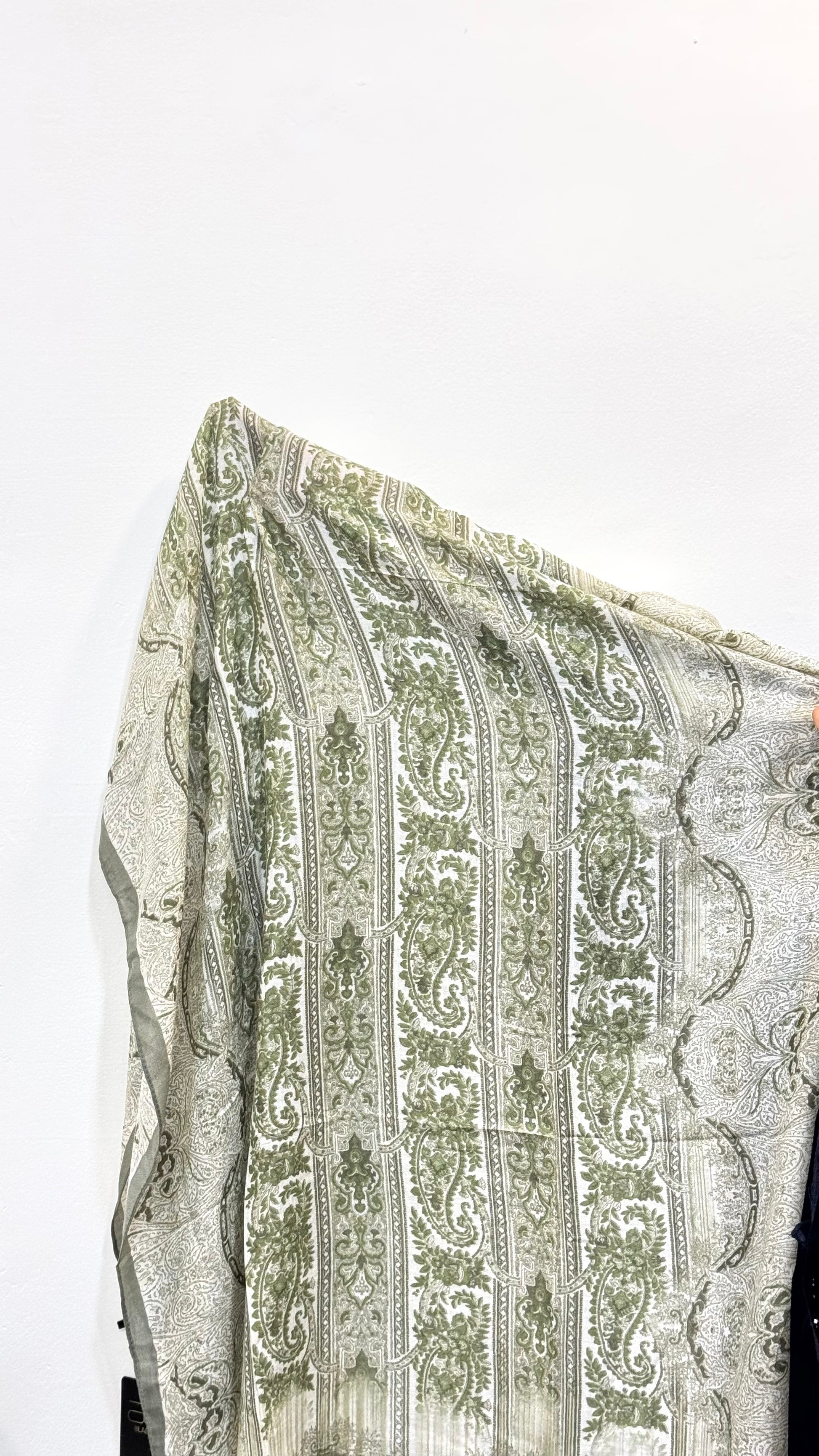 Detailed fabric view of sage green pashmina hijab with print.