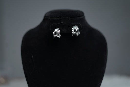 Small silver fold hoops showcased on display holder.