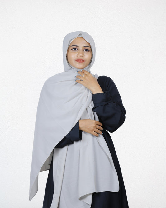 A woman wearing a silver chiffon scarf, adding a subtle shimmer to her outfit.