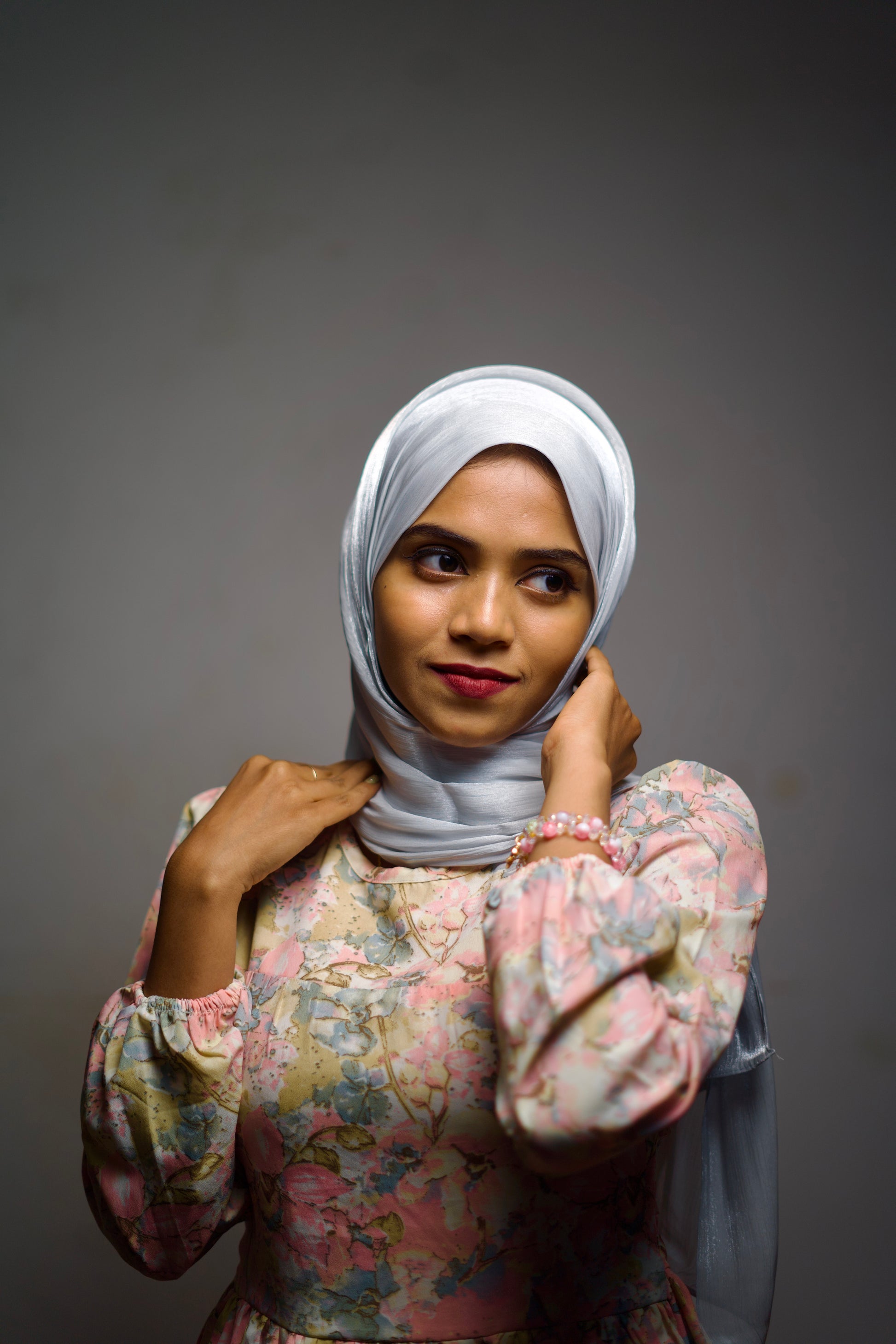 Soft shimmer chiffon hijab in silver, gently wrapped for a polished appearance.