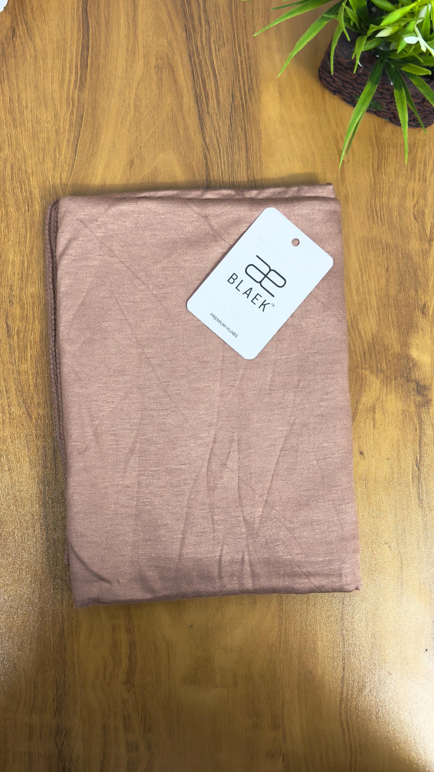 Soft skin-toned jersey hijab, neatly folded for display.