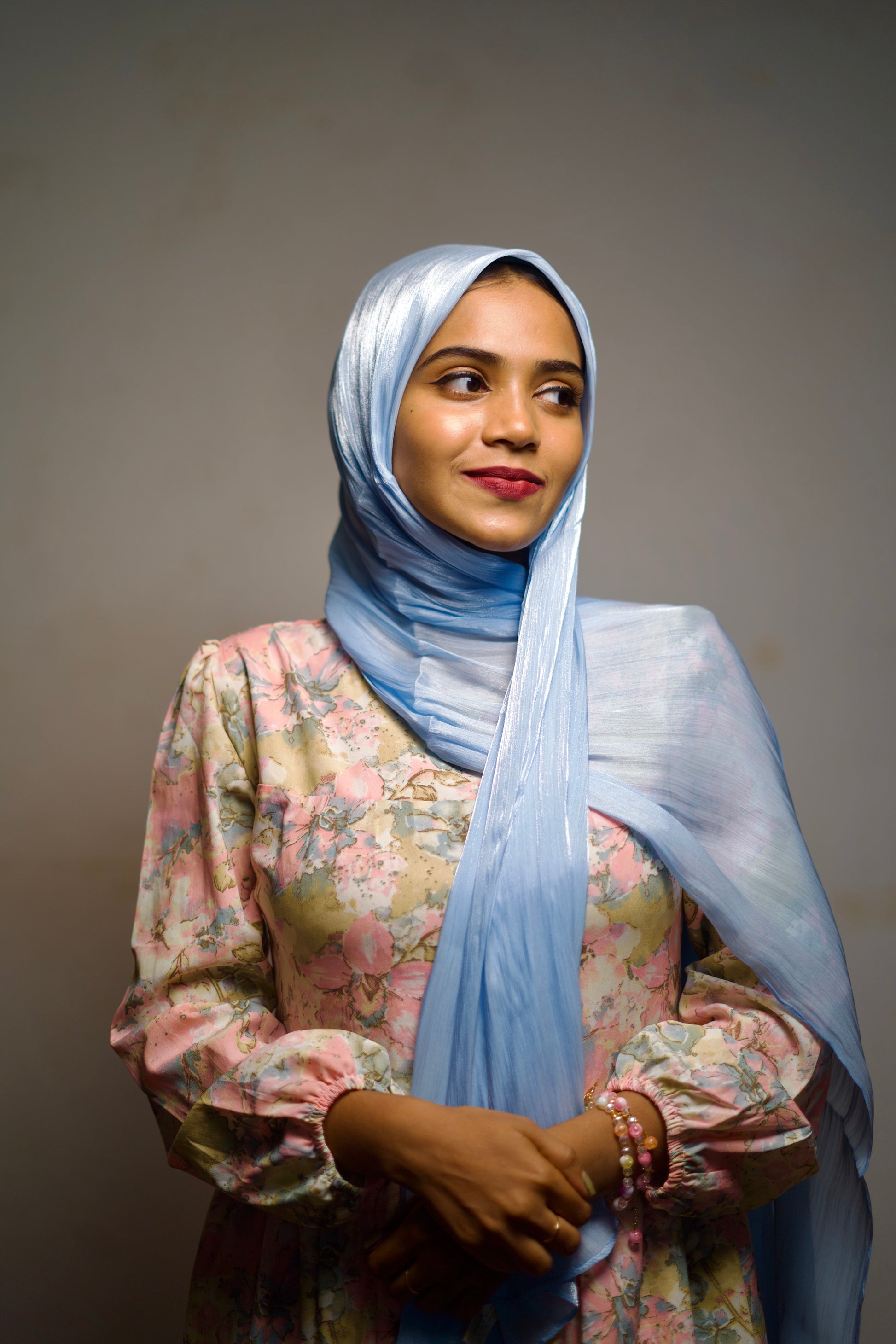 Sky blue shimmer hijab styled neatly with a soft, radiant glow.