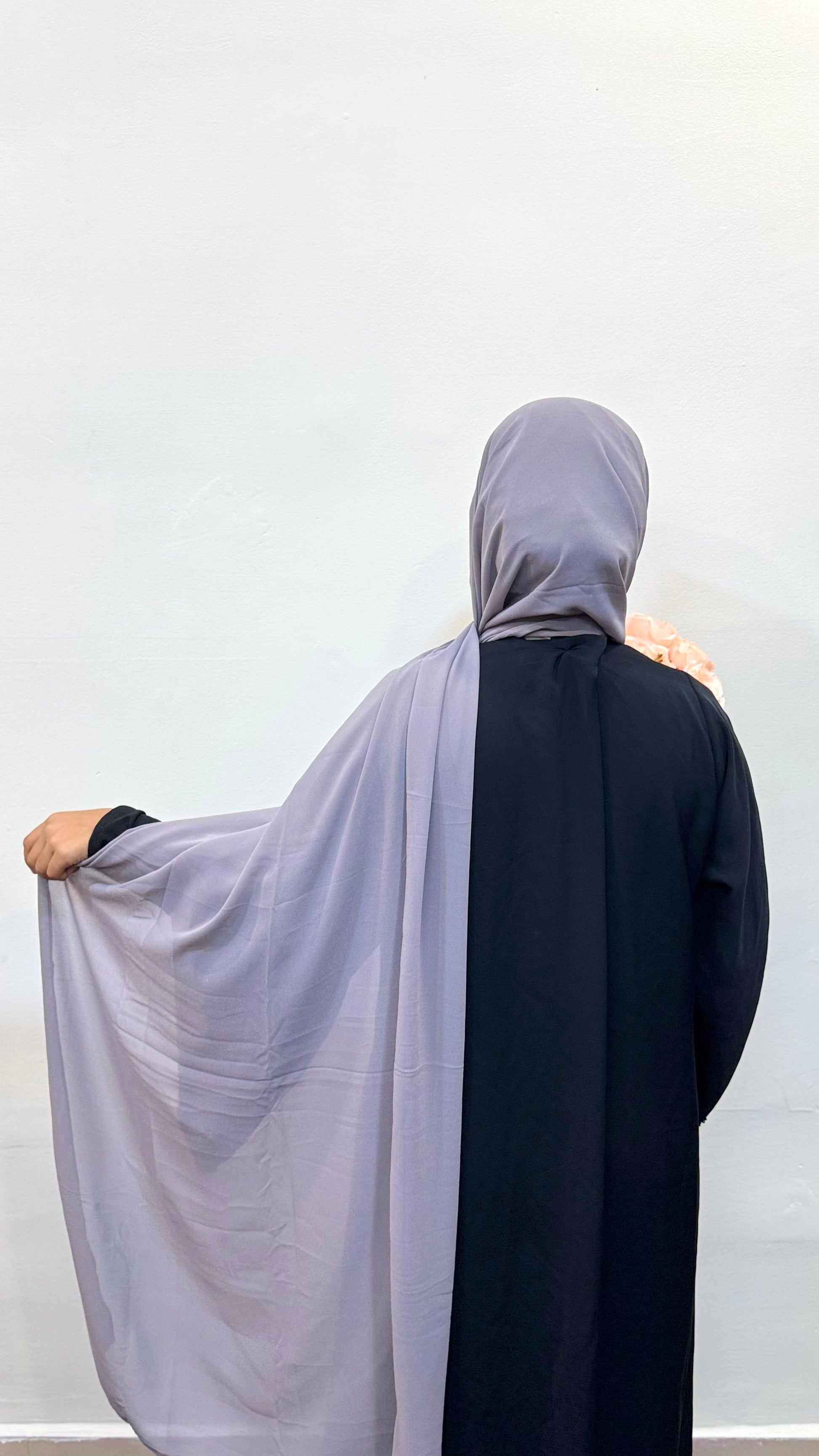 moky grey chiffon scarf flowing smoothly down the back over a black pardha.