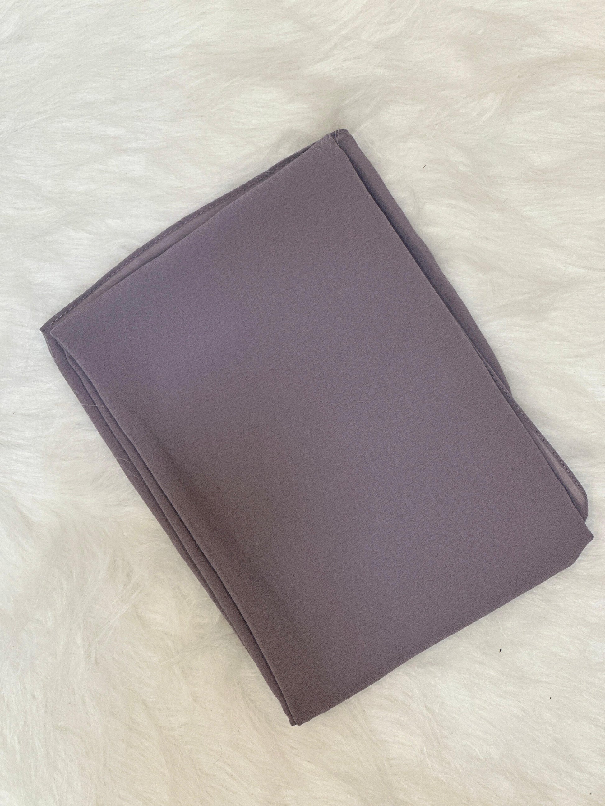 Folded smoke chiffon scarf neatly placed on a flat surface.