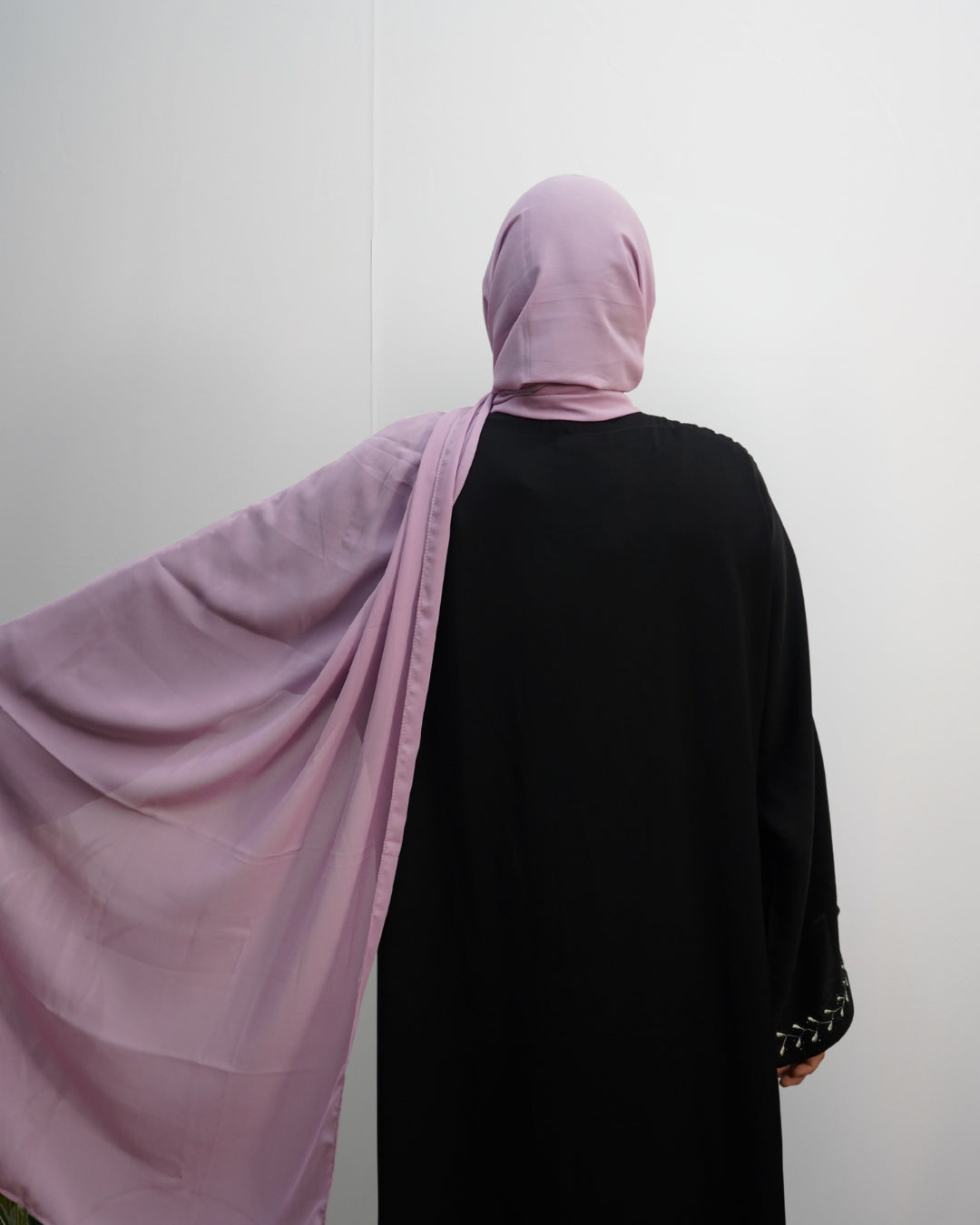 Soft lilac chiffon hijab with a lightweight and flowy drape, shown from back with extended arm.