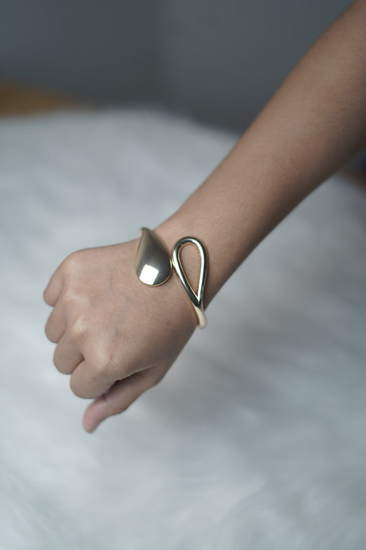 Teardrop Grace Bangle styled on wrist, highlighting sculptural teardrop and leaf design.