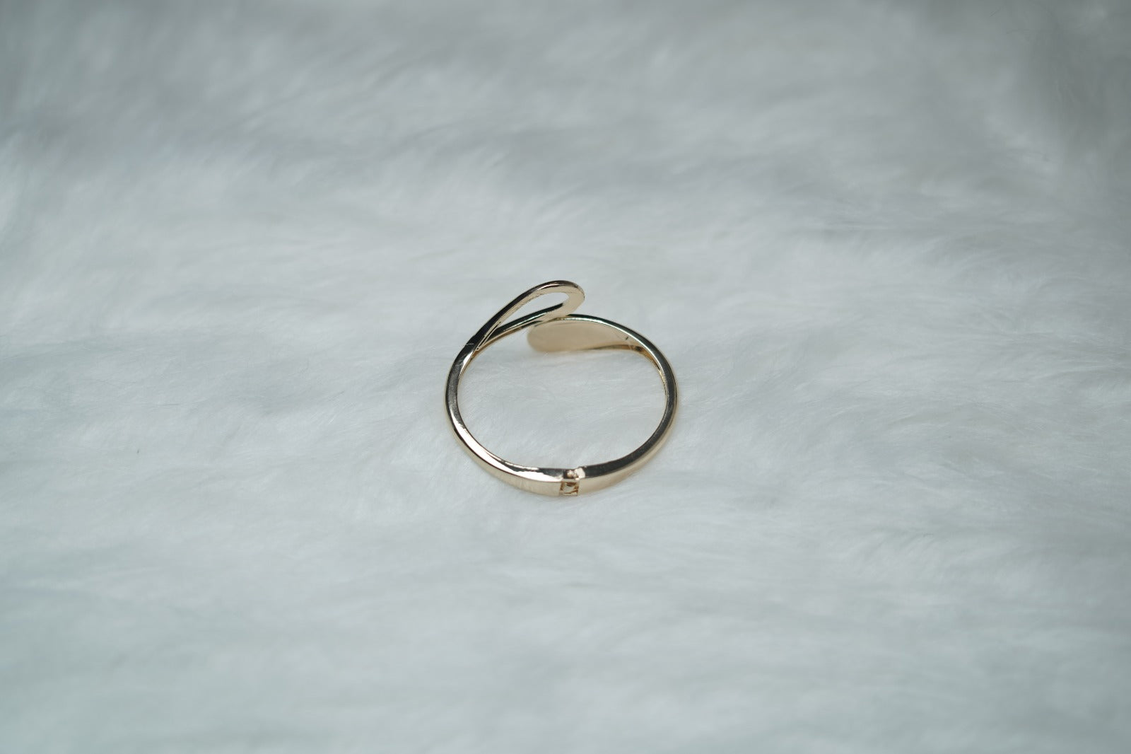 etailed view of gold cuff bracelet with modern sculptural tips.