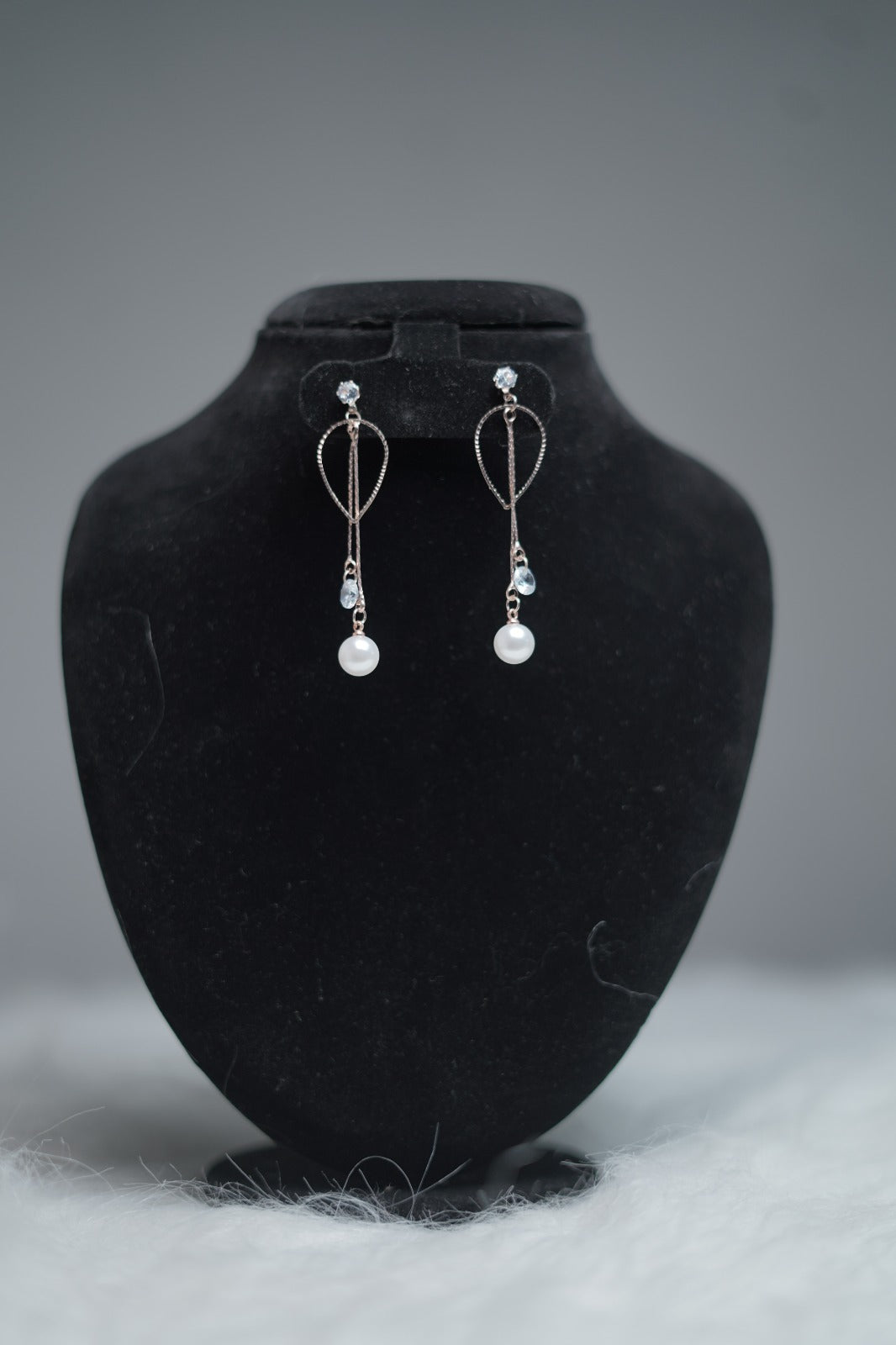 Teardrop Pearl Drape Earrings displayed on earring stand.