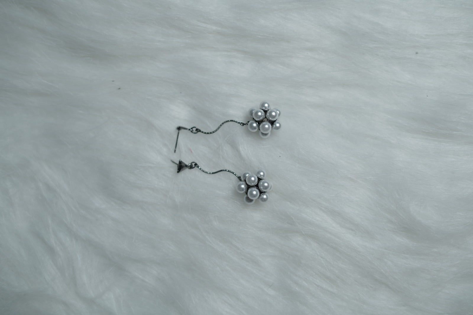 Silver stud and pearl cluster earrings laid flat on white background.