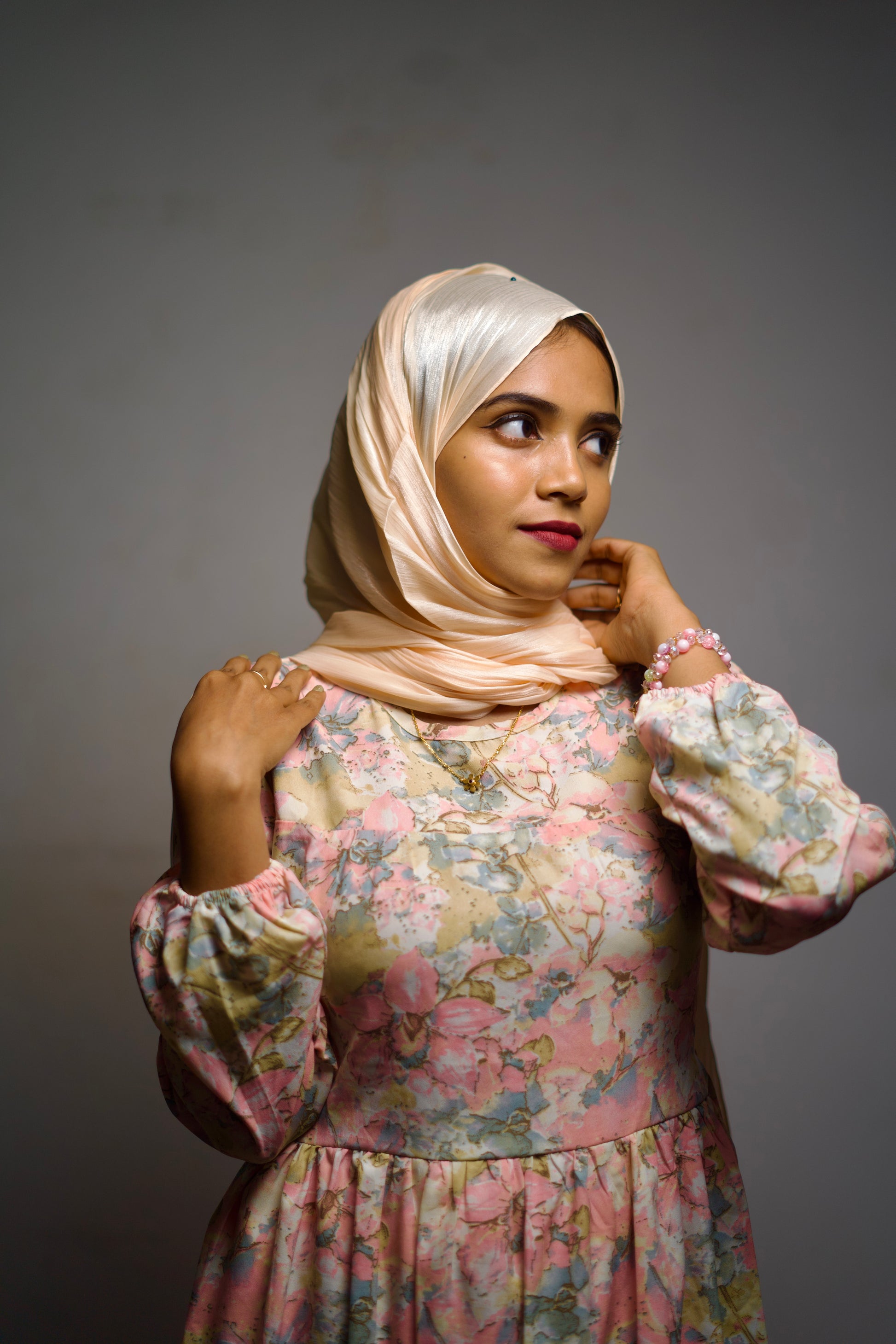 Light golden-beige shimmer scarf worn gracefully around the head and neck.