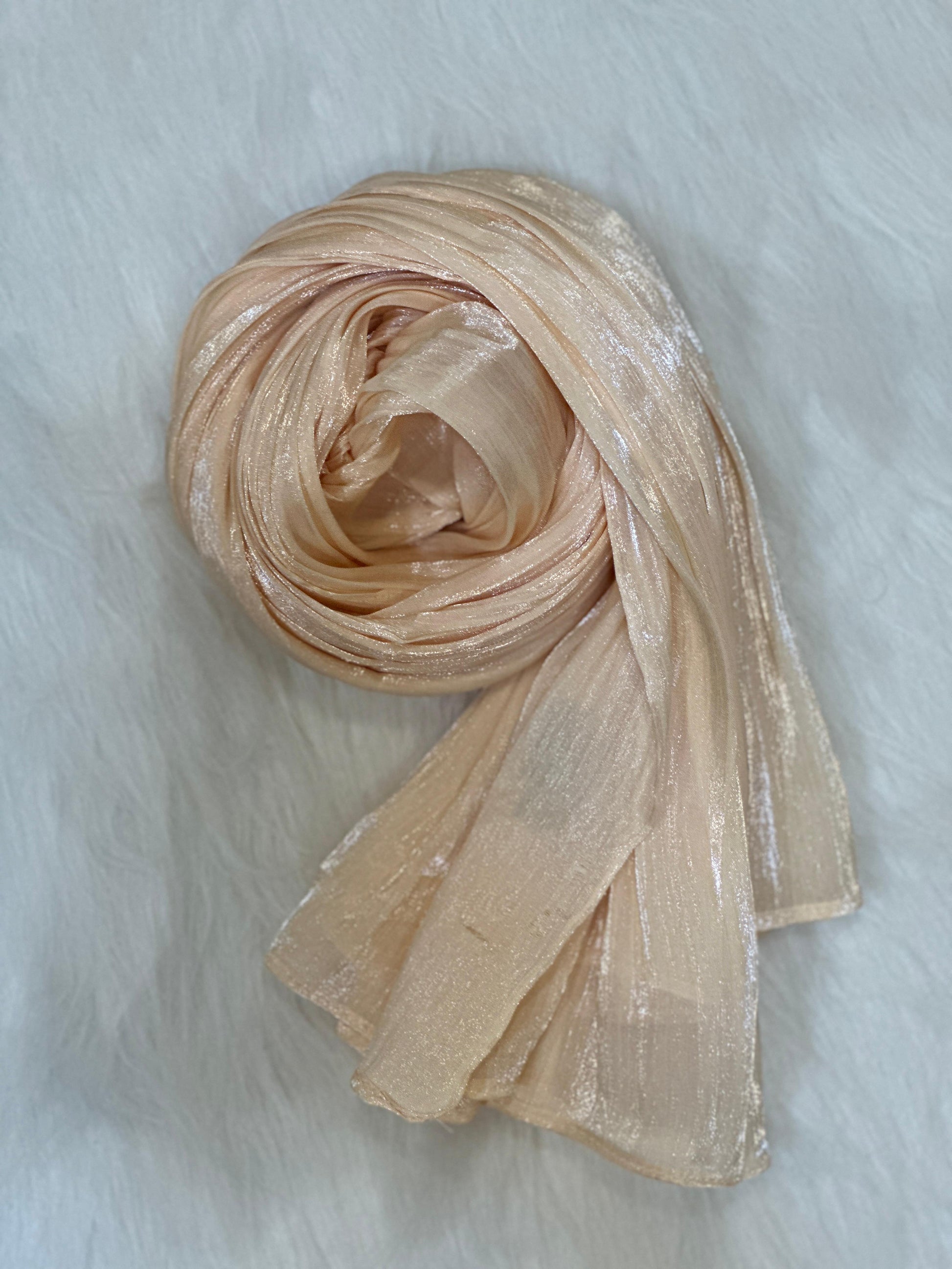 Round-shaped presentation of wheat chiffon hijab with light-catching shimmer.
