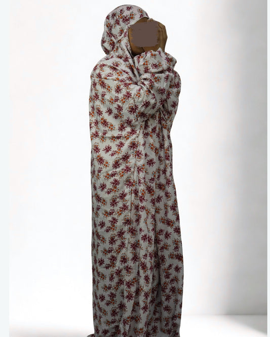 Woman wearing full-length white floral prayer dress with modest coverage.