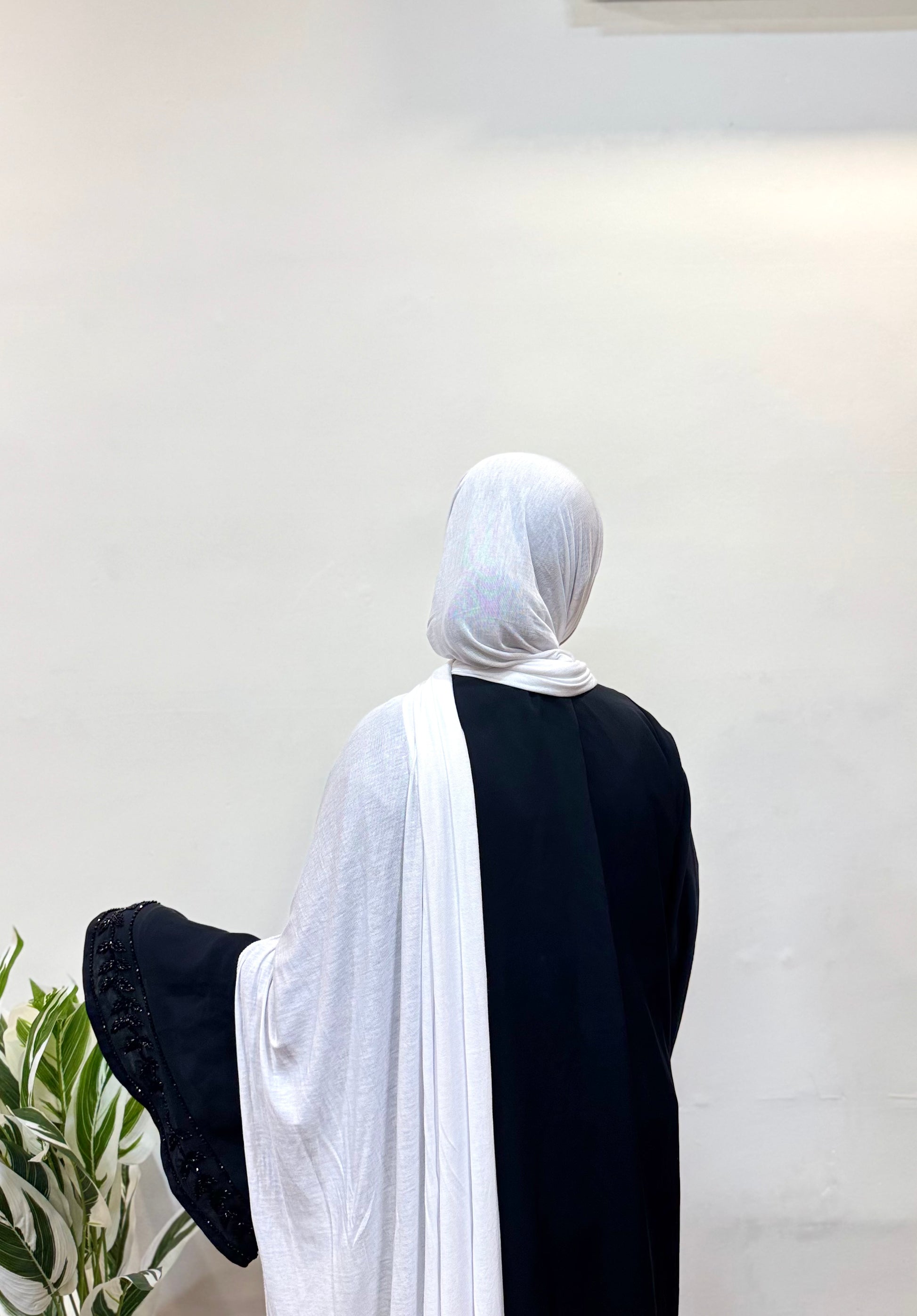 White jersey hijab styled neatly on model with plain background.