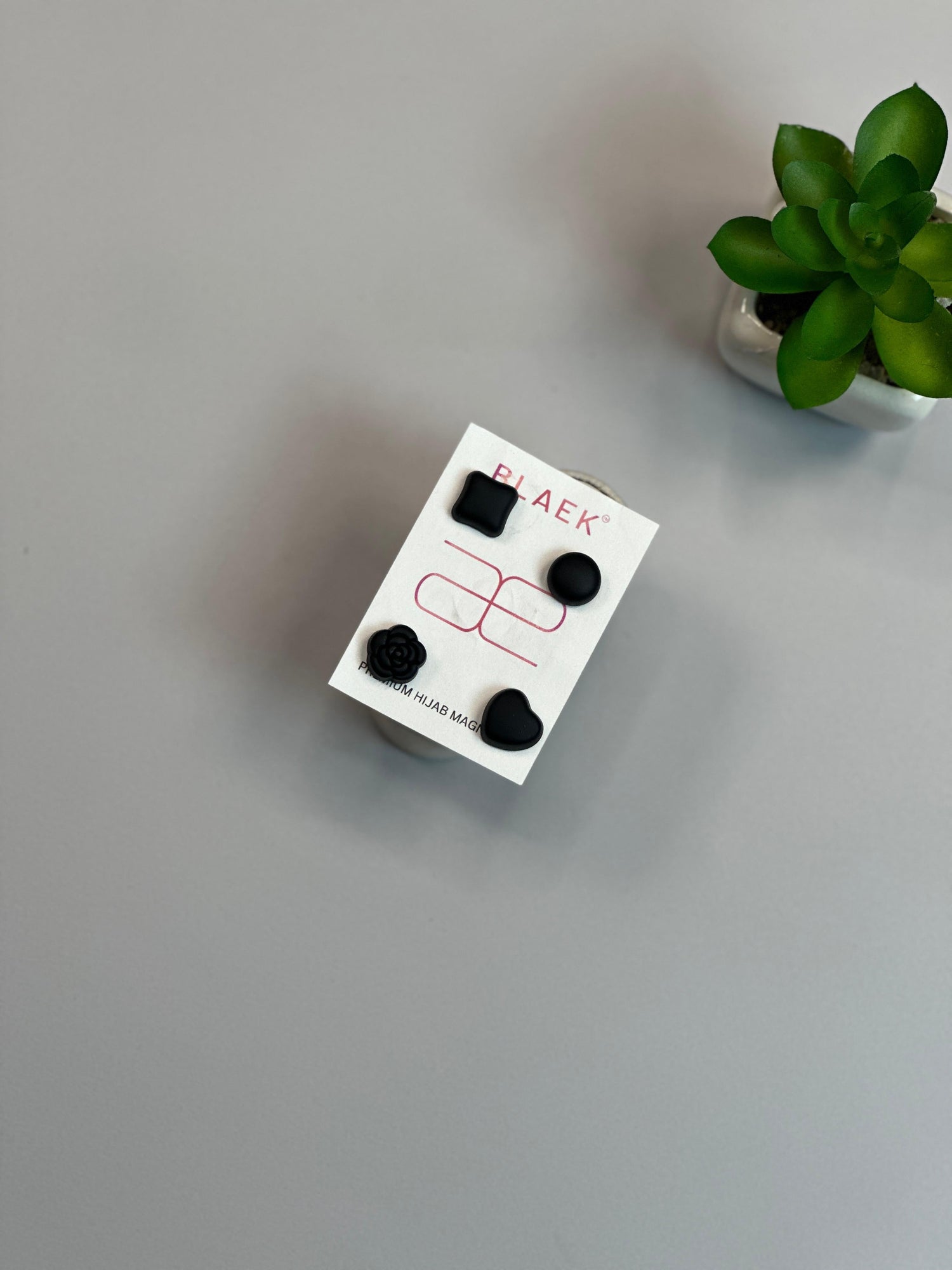Four black hijab magnets in square, round, heart, and flower shapes.