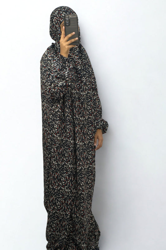 Woman wearing a black abstract printed prayer dress with full coverage.