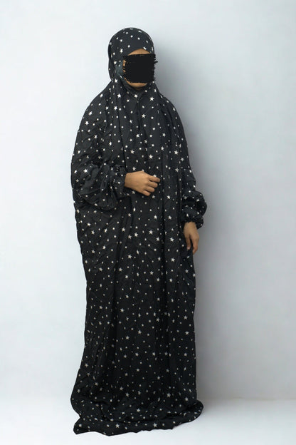 Woman wearing black star print polyester lycra prayer dress with full coverage.