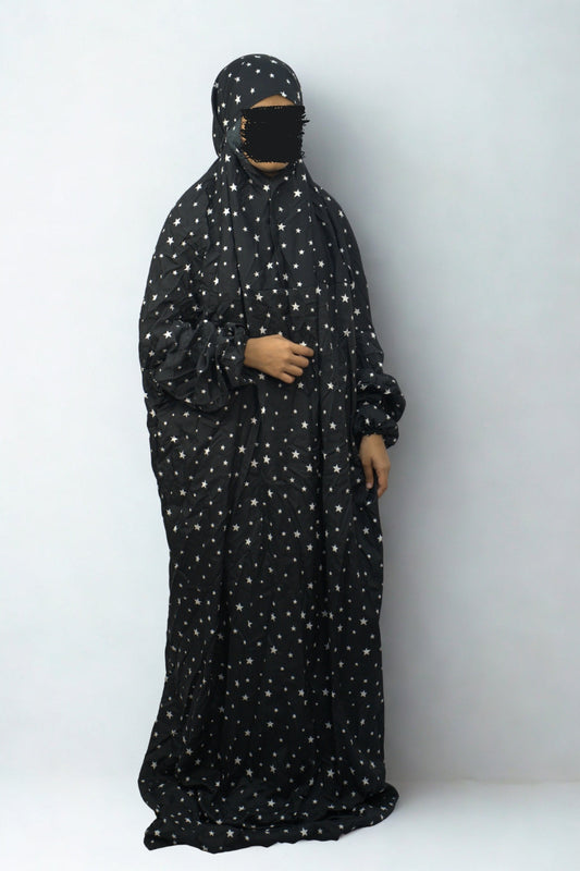 Woman wearing black star print polyester lycra prayer dress with full coverage.