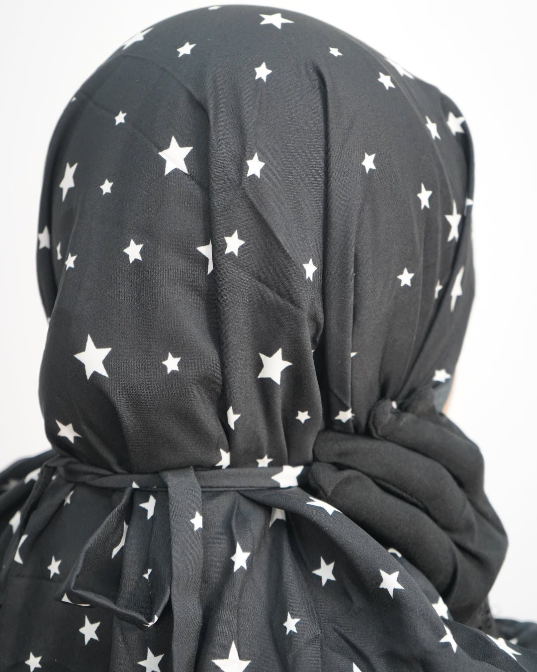 Back view of star print prayer dress showing adjustable tie at head.