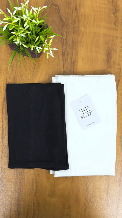 Soft white hijab complemented by a deep black cap for a striking finish.