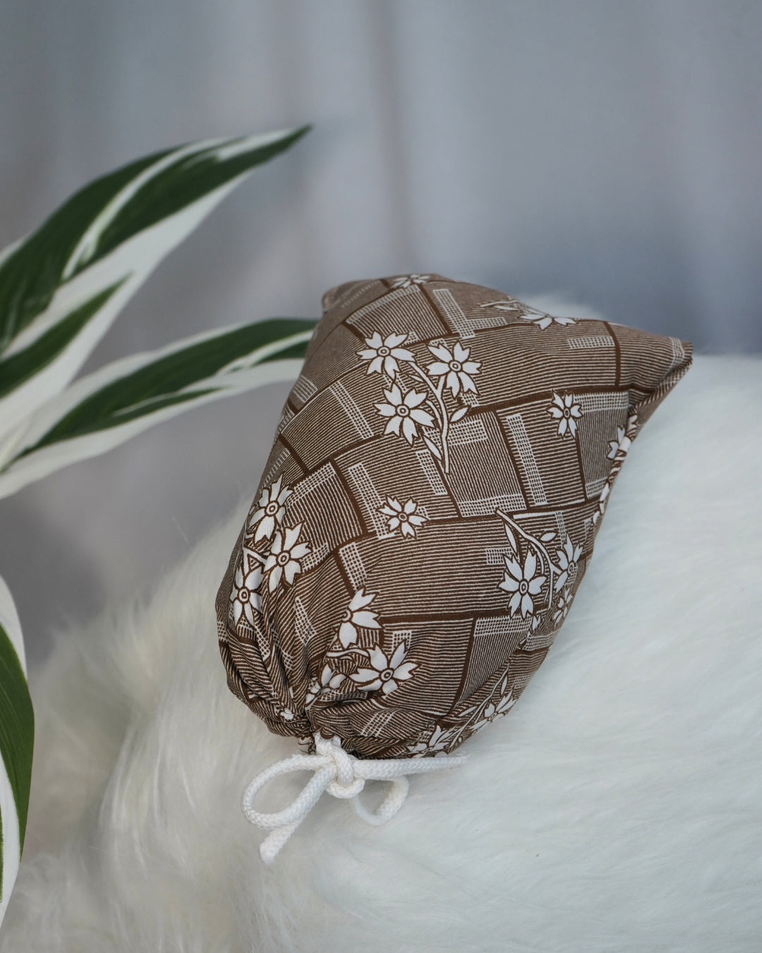 Matching printed pouch with brown floral prayer dress for easy storage and travel.