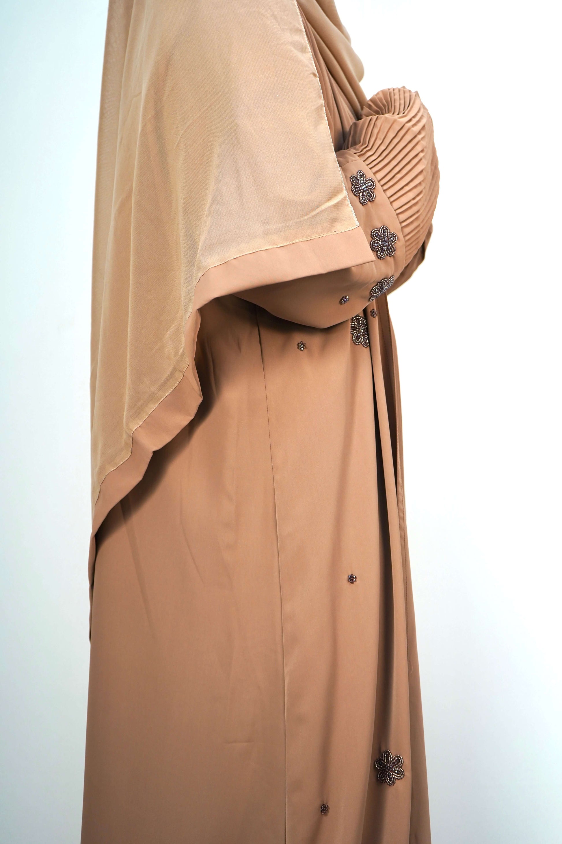 A side-on shot of the Korean Alqa Nidha Abaya in brown, showing the elegant flow of the layered fabric.