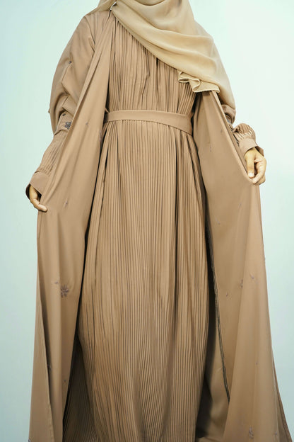 A model wearing the open-front Korean Alqa Nidha Abaya in brown, showcasing the pleated inner layer and elegant drape.