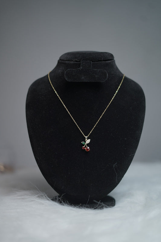 Cute cherry fruit pendant necklace shown on jewelry stand.