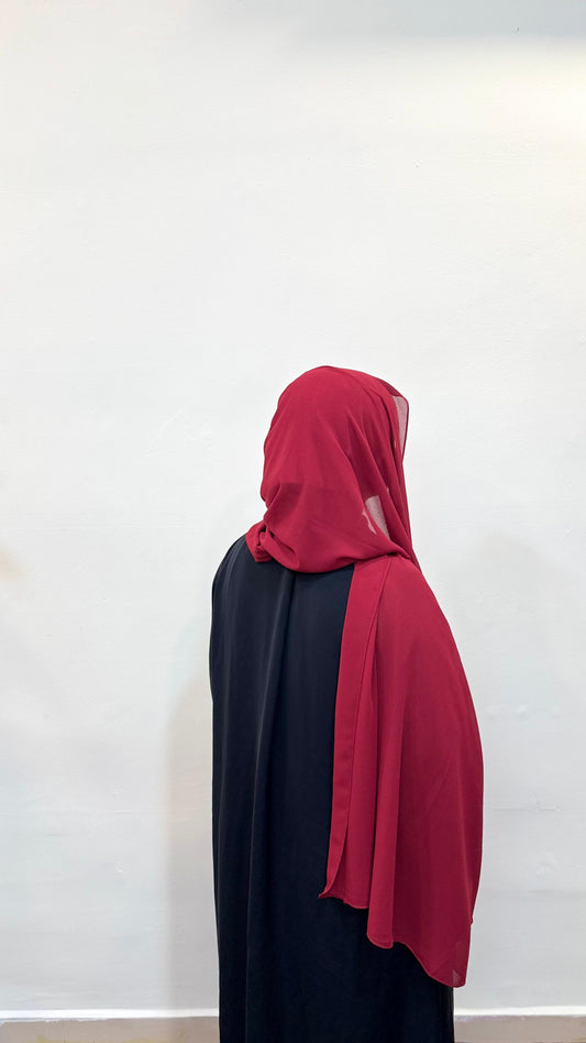 Back angle showing the delicate drape of a cherry chiffon scarf.