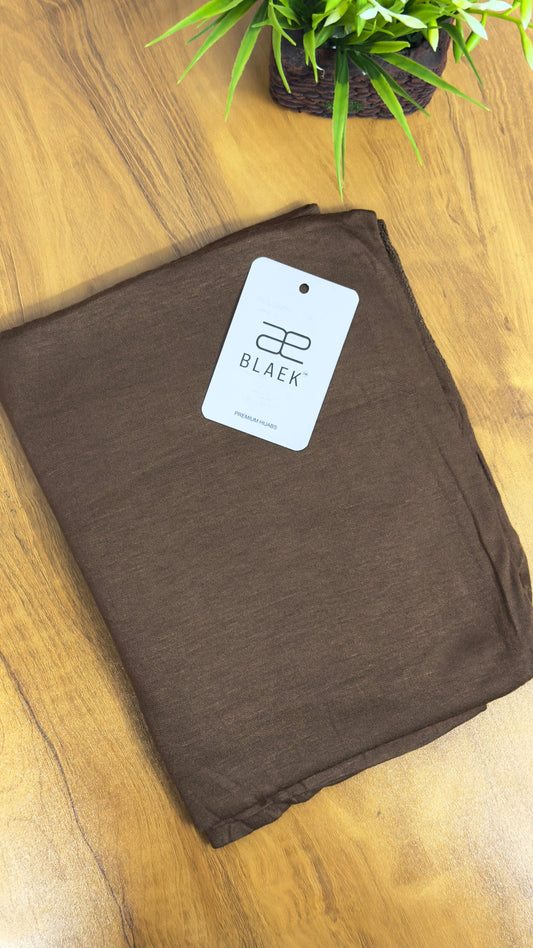 Deep coffee brown jersey hijab, folded with a smooth finish.