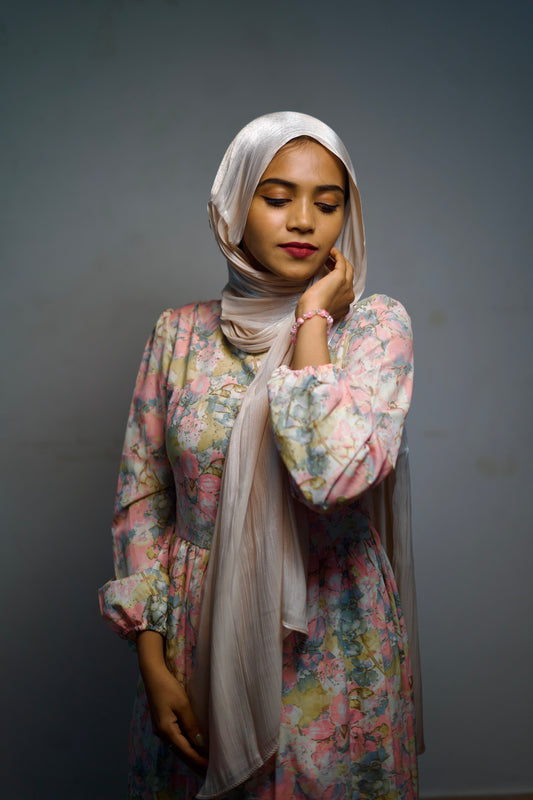 Woman wearing a light cream shimmer hijab.