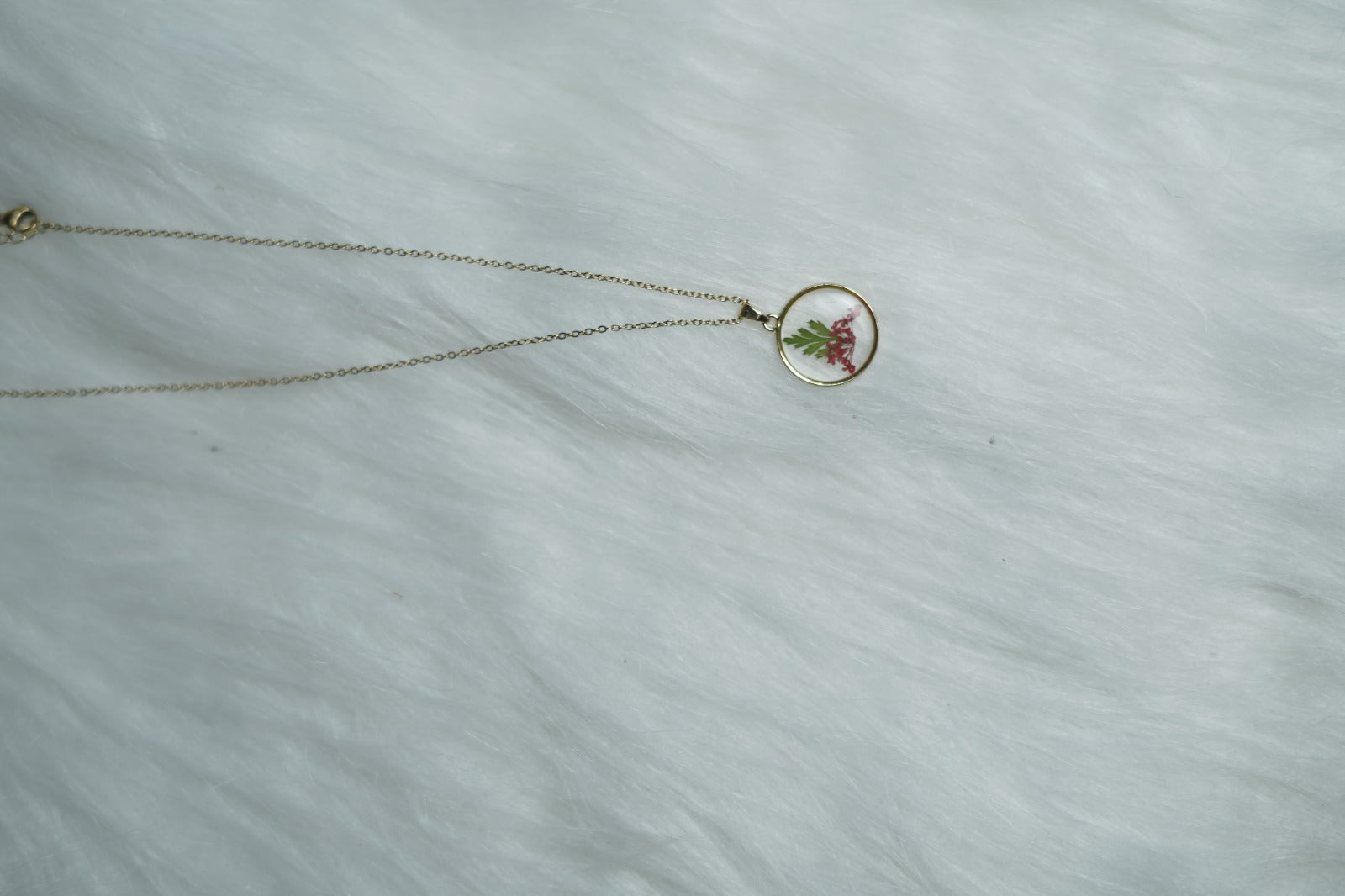 Crimson Leaf Necklace with red and green motif on white backdrop.