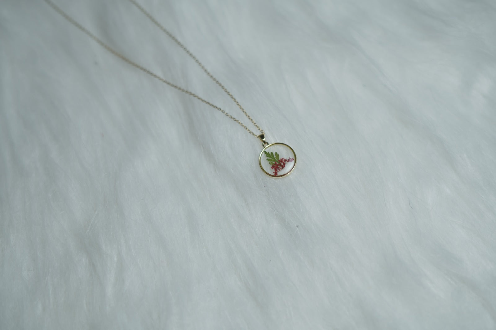 Close-up of Crimson Leaf Necklace showing red floral and leaf design.