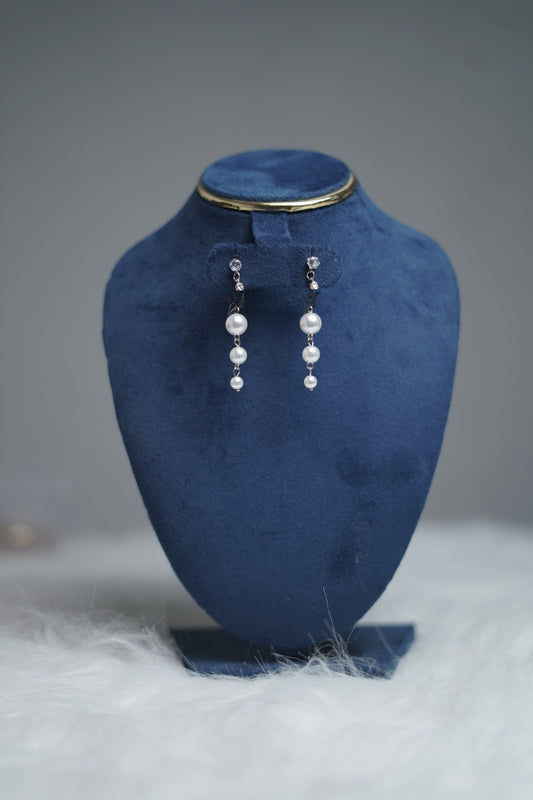 Earrings with crystal top, black bird charm, and white pearls upright.