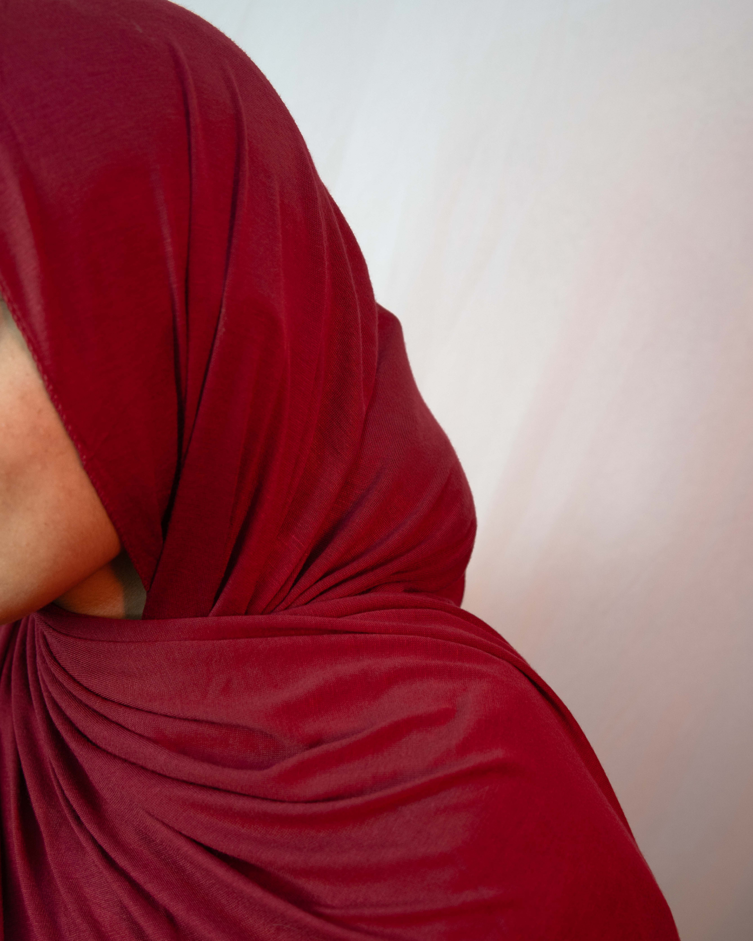 Deep maroon jersey hijab fabric texture close up soft breathable stretch jersey hijab