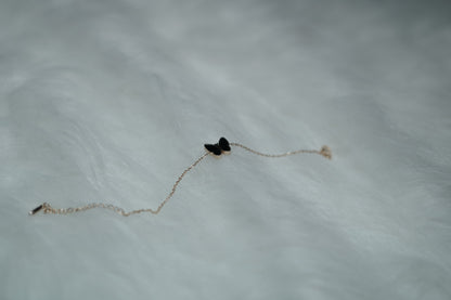 Bracelet displayed with the black butterfly side turned up, laid flat on a neutral surface.
