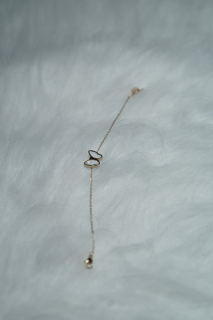 Bracelet styled on hand with the white butterfly side outward, showing a delicate look.