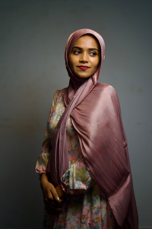 Woman wearing a deep grape-colored hijab with subtle shimmer detailing.