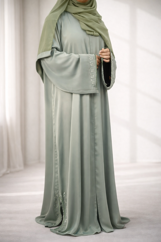 A model wearing the Tiktok Indonesian Abaya in green, showing the leaf-like embroidery on the sleeves.