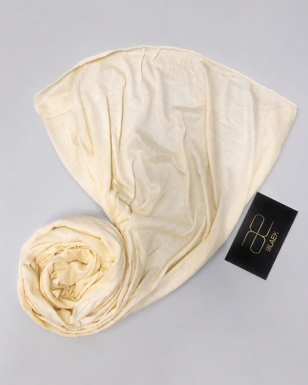 Vanilla kids jersey hijab displayed open with soft fabric folds and a neatly rolled end