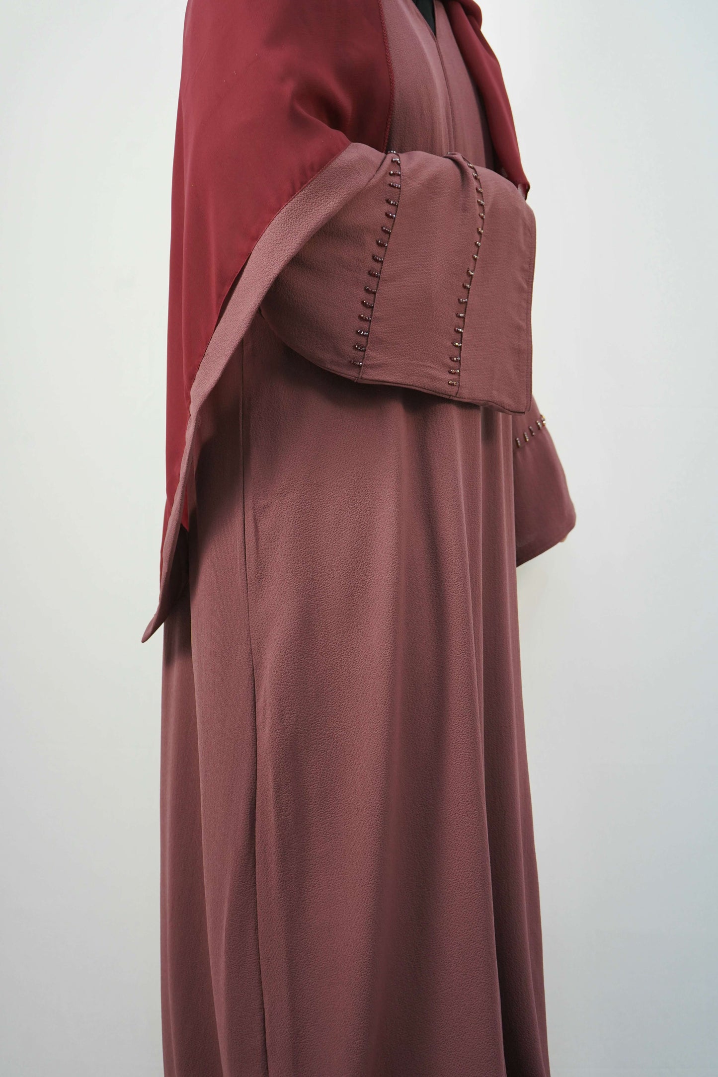A side view of the Korean Bubble Abaya in Old Mauve, showing the elegant flow of the fabric and the unique studded sleeves.